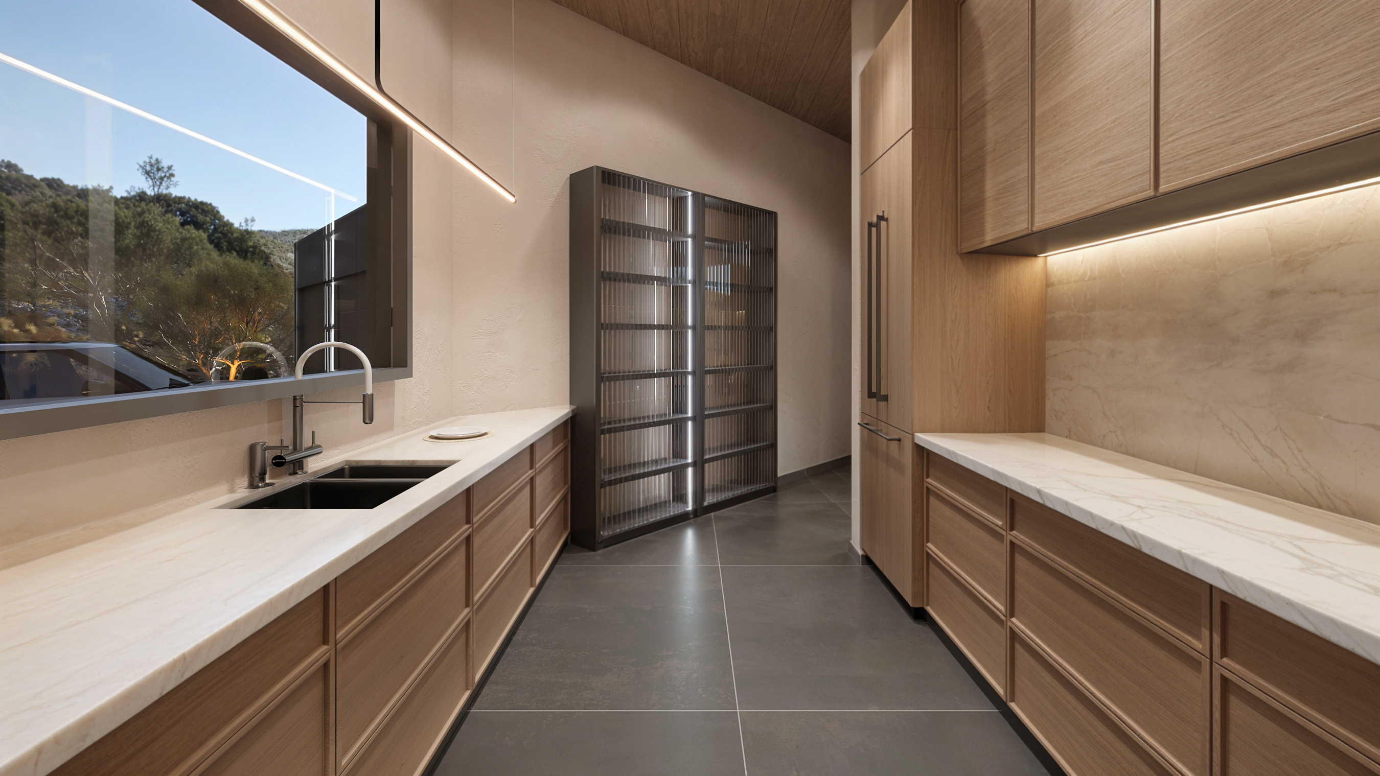 Galley run of the butler's kitchen — prep sink at the window, reeded-glass pantry cabinet and integrated fridge