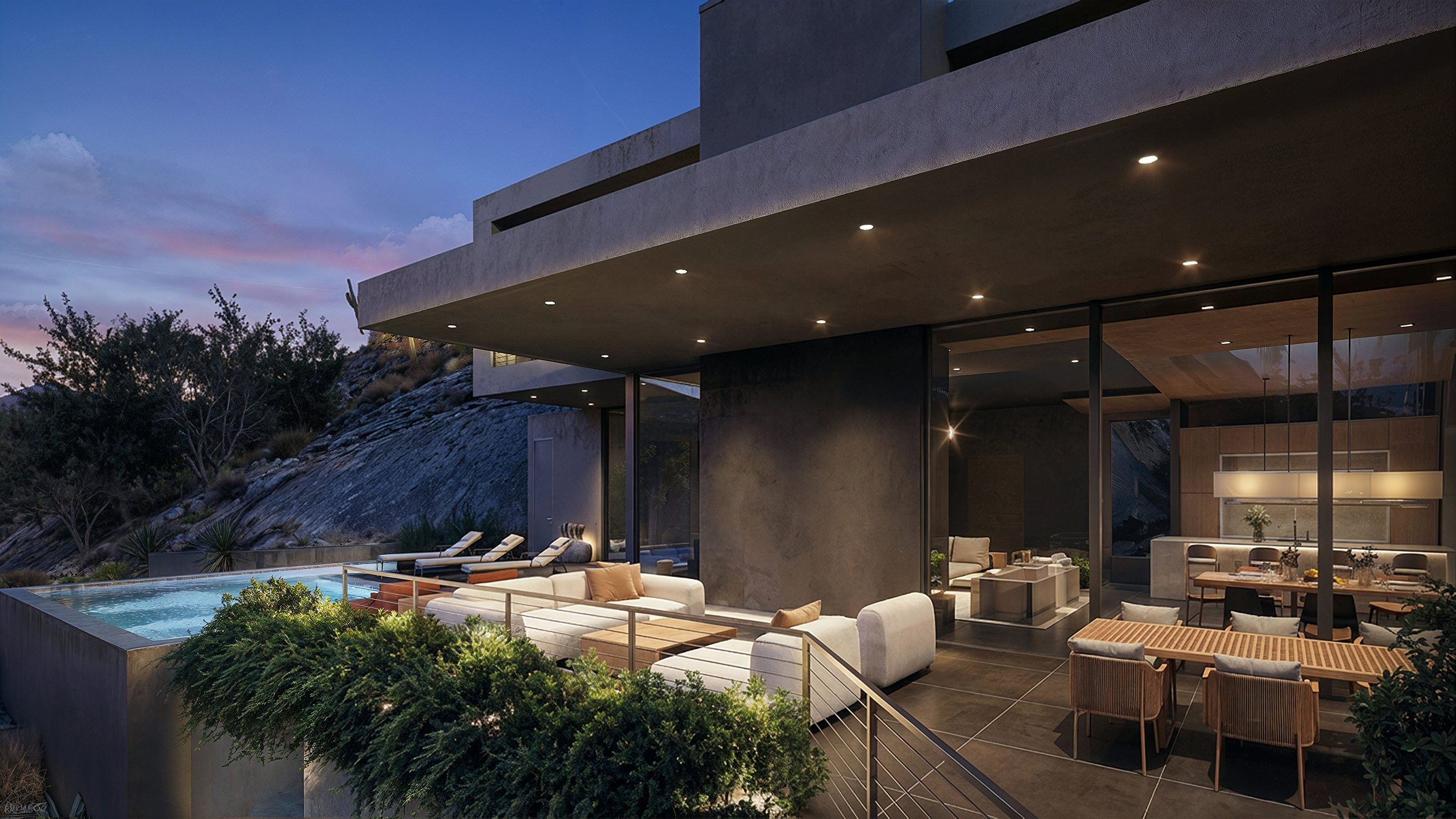 Outdoor dining terrace and pool tucked into the hillside at dusk