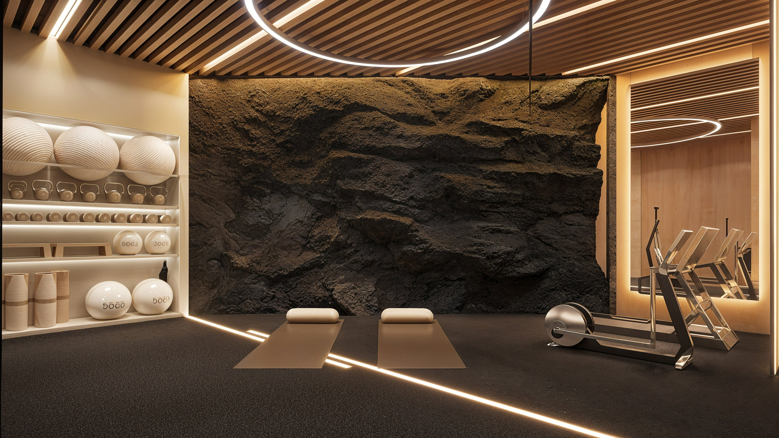 Wide view of the gym with a halo ring pendant, rubber floor, twin mats and a mirrored cardio alcove